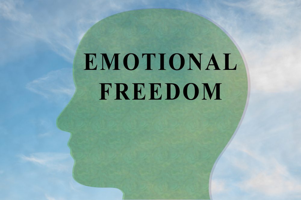 Render illustration of EMOTIONAL FREEDOM title on head silhouette, with cloudy sky as a background.